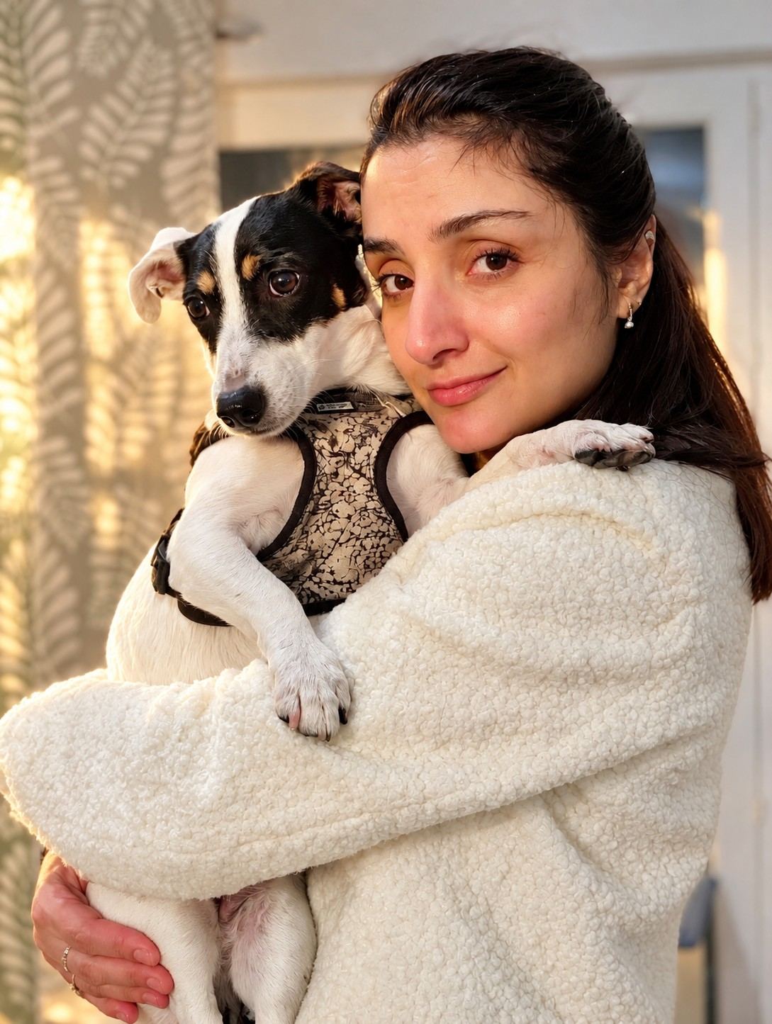 Une femme tient un chien dans ses bras